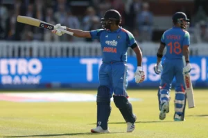 Rohit Sharma in India's blue cricket jersey looking determined under dramatic stadium lights, symbolizing his remarkable comeback after scoring a match-defining century and silencing retirement critics.